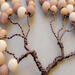 details of tiny branches adorned with wood beads of various sizes and colors